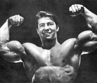 fisiculturista Larry Scott fazendo uma pose de duplo bíceps