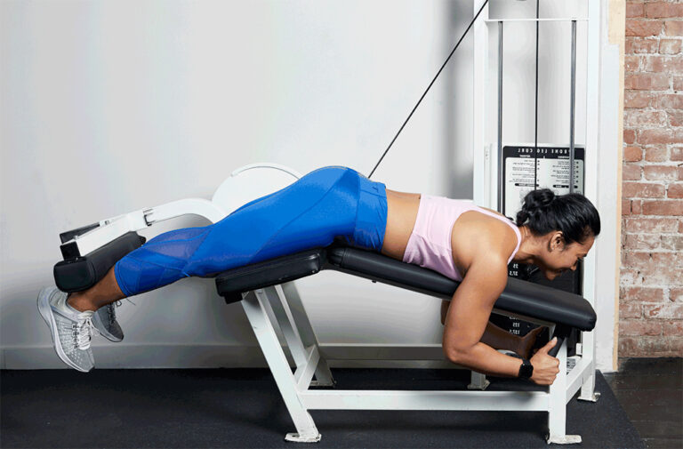 mulher fazendo o exercício de posterior na mesa flexora