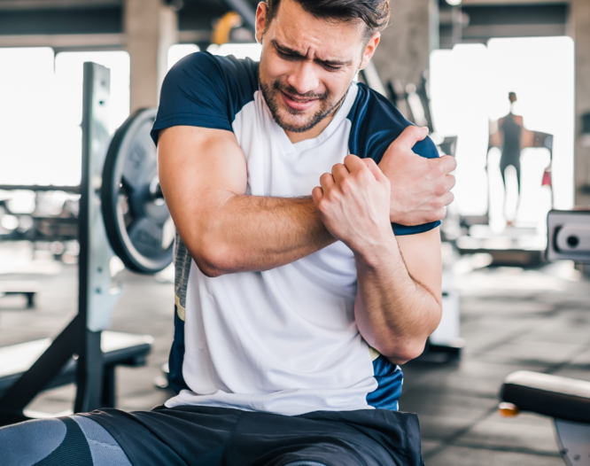 praticante de musculação sentindo dor no ombro na academia